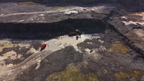 Granite quarry work in progress with heavy machinery and water pools on the Stock Footage 335377985