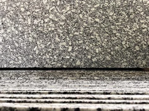 A granite slab displayed on vertically stacked granite slabs in a factory. Stock Photos
