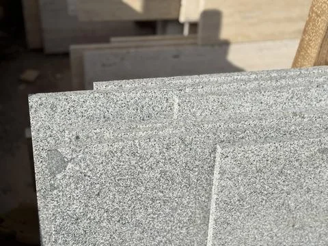 Granite slabs with speckled pattern stacked in sunlight, ideal for construc.. Stock Photos