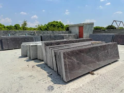 Granite slabs vertically stacked in groups in a granite warehouse Stock Photos