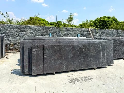 Granite slabs vertically stacked in groups in a granite warehouse Stock Photos