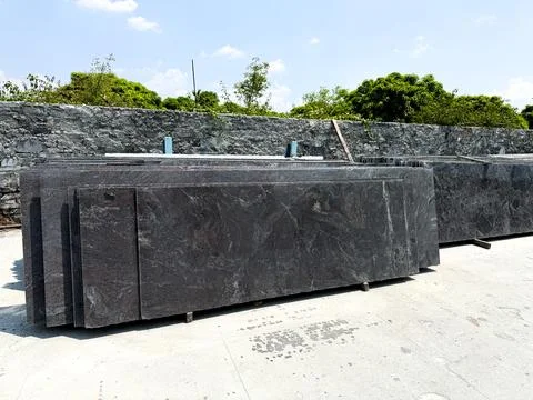 Granite slabs vertically stacked in groups in a granite warehouse Stock Photos