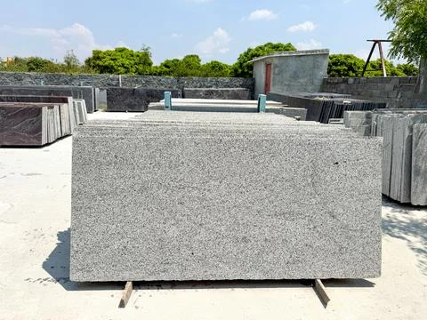 Granite slabs vertically stacked in groups in a granite warehouse Foto stock