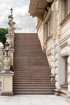 Granite staircase on the side of the facade of the building made of stone. Stock Photos