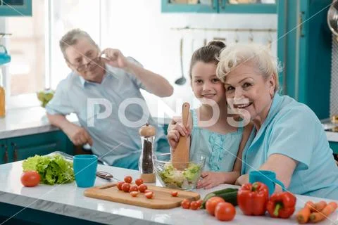 Granny and granddaughter embrace near kitchen table Stock Photos