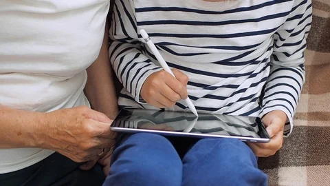 Granny and grandson using tablet while sitting on sofa in apartment. Stock Footage 109197372