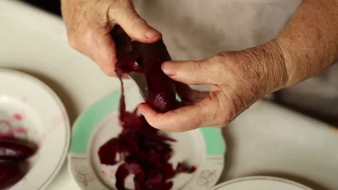 Granny cleans beets. Preparation of a dish herring under a fur coat. Stock Footage 70269152