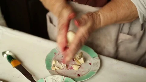Granny cleans boiled egg. Preparation of a dish herring under a fur coat. Stock Footage 70269203