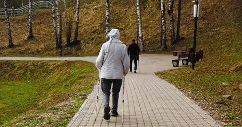 Granny is engaged in Nordic walking, an elderly woman walks with sticks Stock Footage 274092039