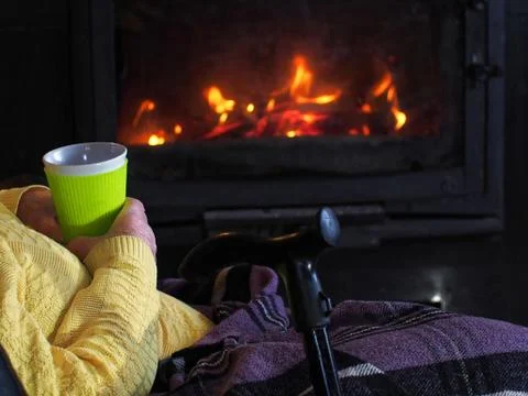Granny by the fireplace with a Cup Stock Photos