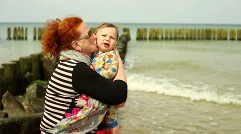 Granny kisses a baby at the beach | Stock Video | Pond5