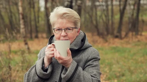Granny in the Park drinking tea Stock Footage 81658707
