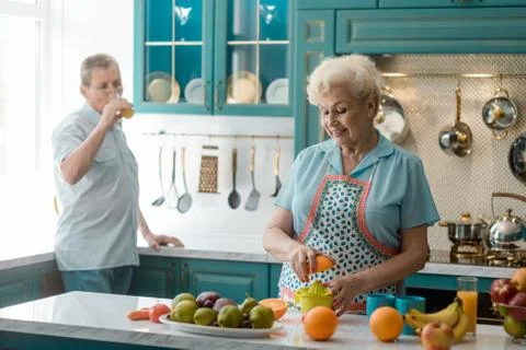 Granny squeezing a half of an orange with a plain juicer Stockfoto's