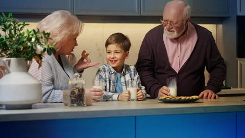 Granny telling funny stories to smiling grandson during happy family lunch Stock Footage 325132571