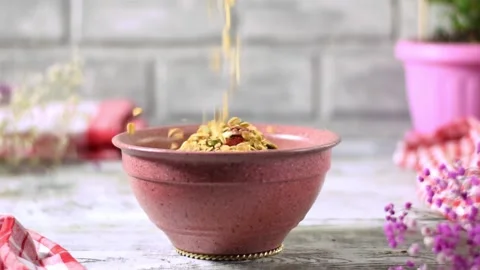 Granola falling into ceramic bowl Stock Footage 191076304