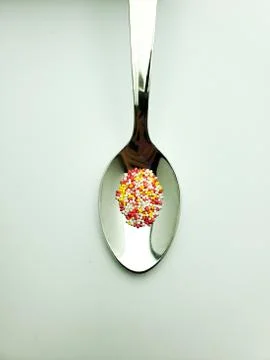 Granules from capsules in a teaspoon on an isolated background Stock Photos