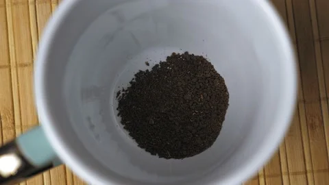Granules of instant black coffee fall to the bottom of the white mug. Making Video stock 229983054