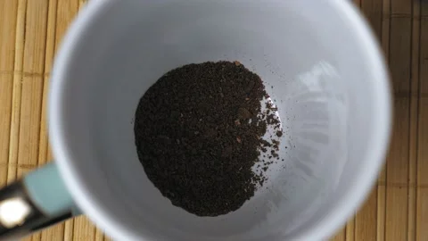 Granules of instant black coffee fall to the bottom of the white mug. Making Video stock 230192654