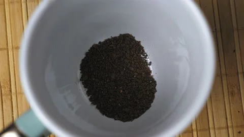 Granules of instant black coffee fall to the bottom of the white mug. Making Video stock 230224942