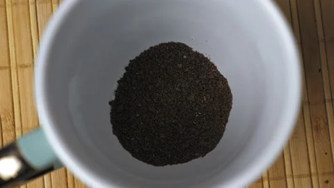 Granules of instant black coffee fall to the bottom of the white mug. Making Stock Footage 231444568