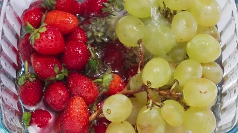 Grape And Strawberry Under Running Water – Fresh Fruit Washing Close Up Stockbeeldmateriaal 335958599
