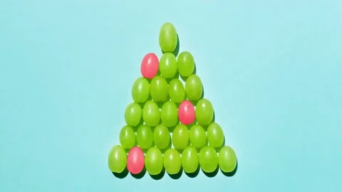 Grape berries shape a Christmas tree on a blue background. Vidéo 143492838