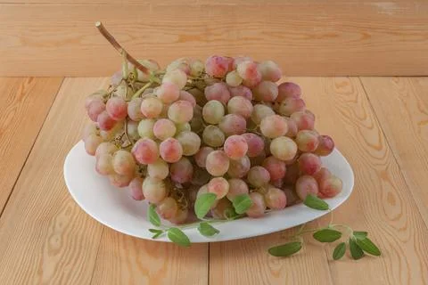 Grape. a bunch of grapes. Dark blue Isabella. and red grapes on a white saucer.  Stock Photos