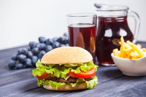 Grape juice, hamburger on the table Stock Photos