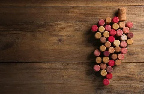 Grape made of wine bottle corks on wooden table, top view. Space for text 스톡 사진