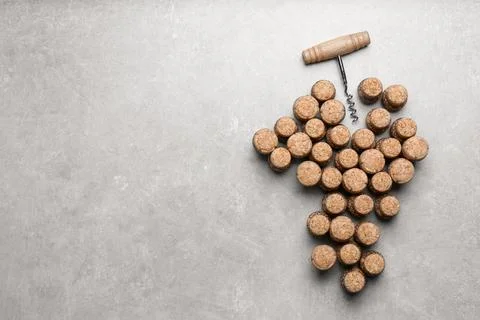 Grape made of wine bottle corks and corkscrew on light grey table, top view.. 스톡 사진