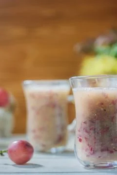 Grape smoothie over the white table. Stock Photos