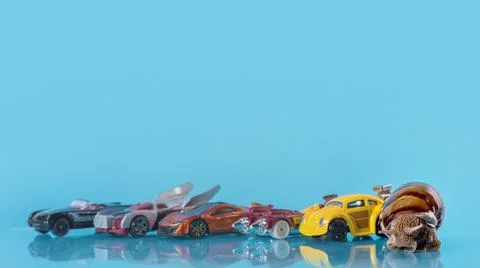 Grape snail in the foreground and background Many multi-colored toy cars on b Foto stock