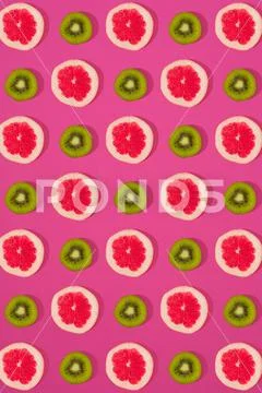 Grapefruit and kiwi pattern on pink background. Minimal flat lay concept. Stock Photos
