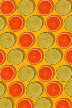 Grapefruit and lime pattern on yellow background. Minimal flat lay concept. Stock Photos