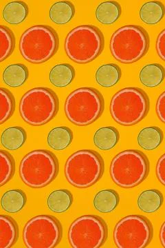 Grapefruit and lime pattern on yellow background. Minimal flat lay concept. Stock Photos