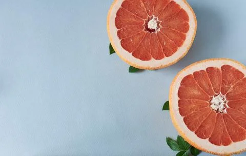 Grapefruit on blue background. Top view, copy space. Grapefruit halves. Stock Photos