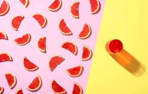 Grapefruit cold drink and grapefruit slices in sunlight. Summer fruits Stock Photos
