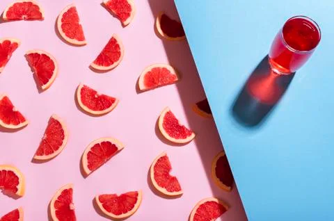 Grapefruit drink on blue background. Fresh grapefruit slices pattern Foto stock
