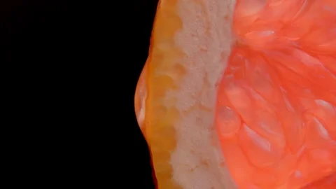 Grapefruit with dripping clear juice on black background Stock Footage 251973742