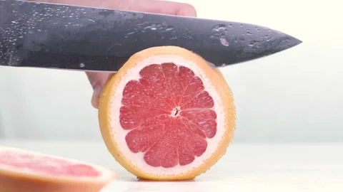 Grapefruit fillets and half of a red grapefruit on a marble chopping board and Stock Footage 88358184