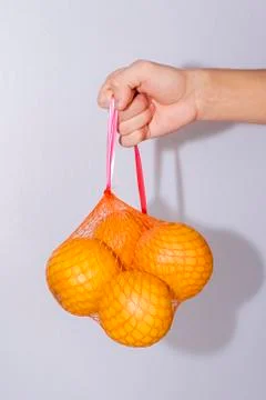 Grapefruit in the grid keeps a hand on a white background Stock Photos
