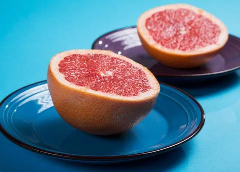 Grapefruit halves close-up on a plate on a blue background Stock Photos
