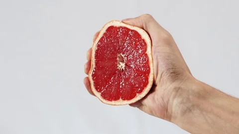 Grapefruit, hand squeezes out juice closeup Stock Footage 72239330