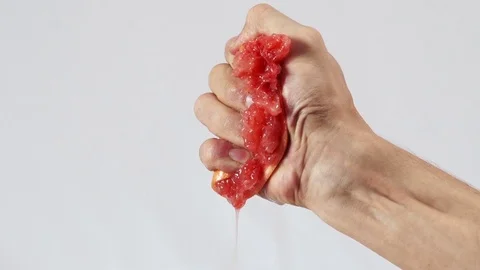 Grapefruit, hand squeezes out juice closeup Stock Footage 72239416