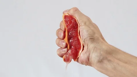 Grapefruit, hand squeezes out juice closeup Stock Footage 72239445