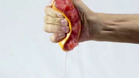 Grapefruit, hand squeezes out juice closeup Stock Footage 72251338
