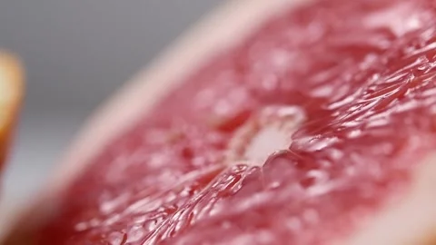 Grapefruit juice flowing down a cut fruit. Stock Footage 131998428