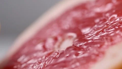 Grapefruit juice flowing down a freshly cut half of grapefruit. Stock Footage 131998441