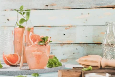 Grapefruit juice with mint in glasses on the table. Refreshing summer cocktai Stock Photos