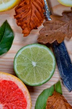 A grapefruit lemons and a lime cut and put on wood with leaves Stock Photos